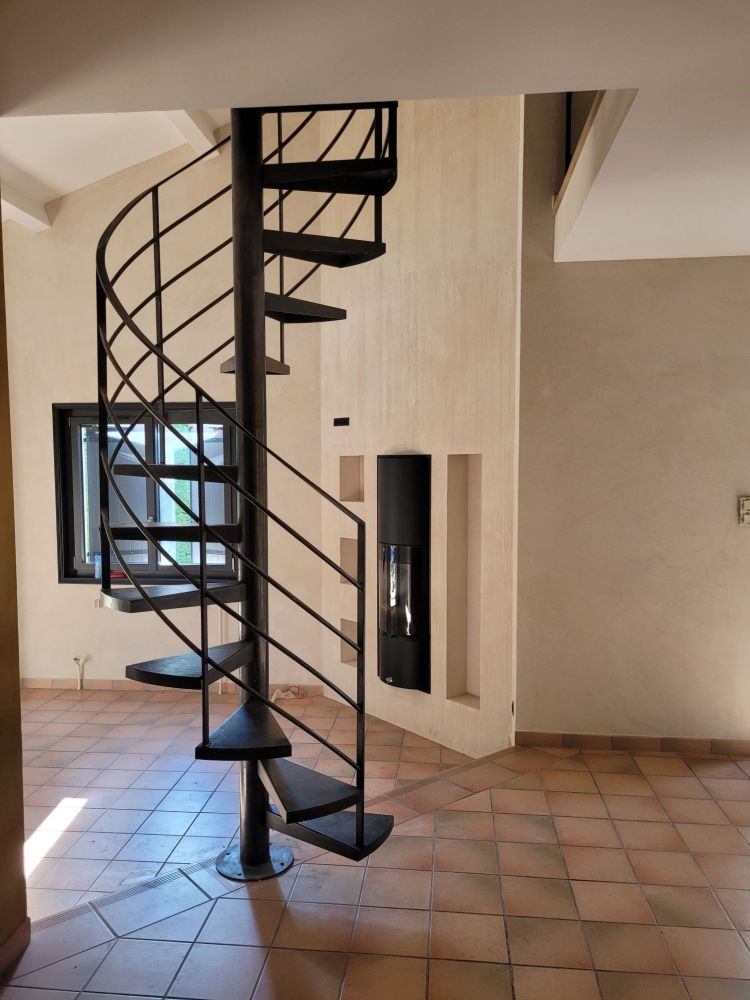 fabrication et pose d'un escalier hélicoïdal sur mesure en acier a Brignais proche de Lyon avec garde-corps métal verre le tout en finition patine cirée