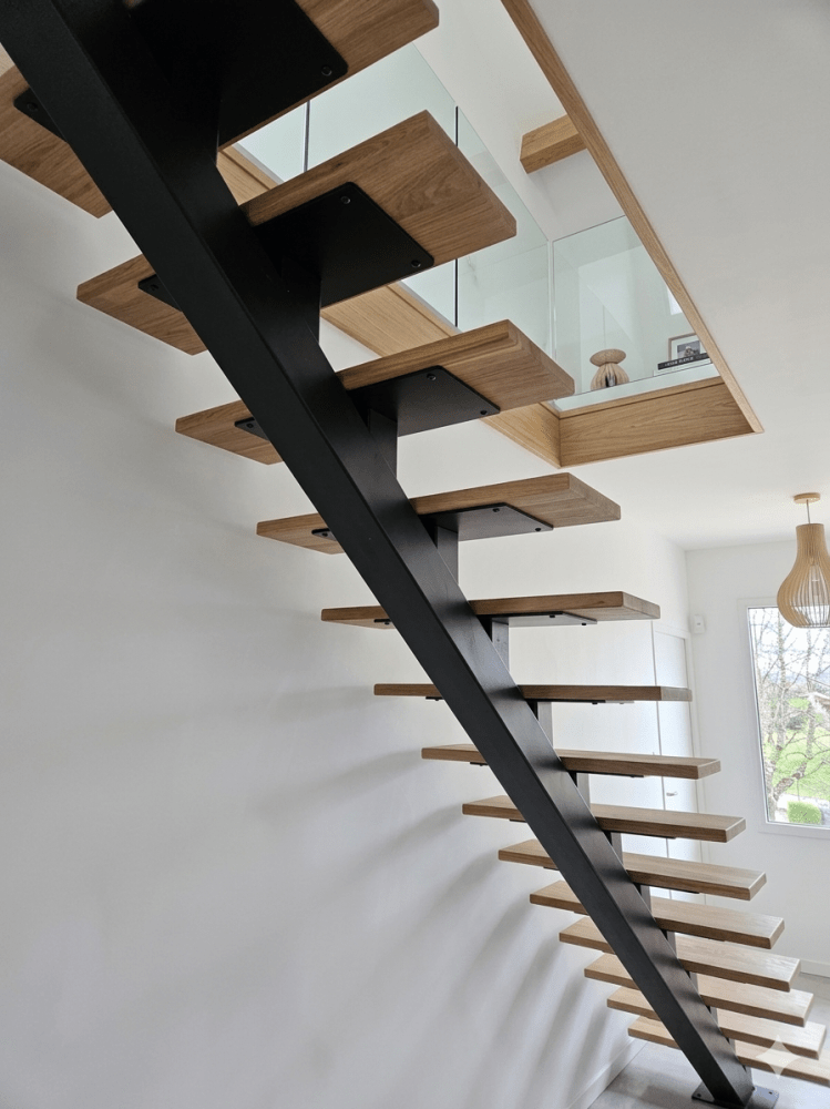 Escalier limon central en acier sur-mesure avec marche en chêne dans l'Ouest Lyonnais